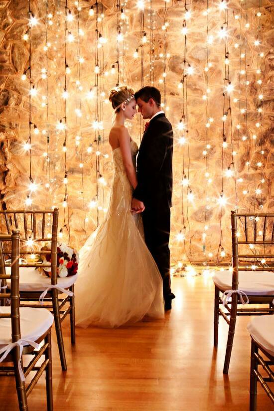 Loving the beautiful backdrop of lights, the bride and groom sharing an intimate moment, and her cute head band - everything about this photo is gorgeous and breathtaking! 